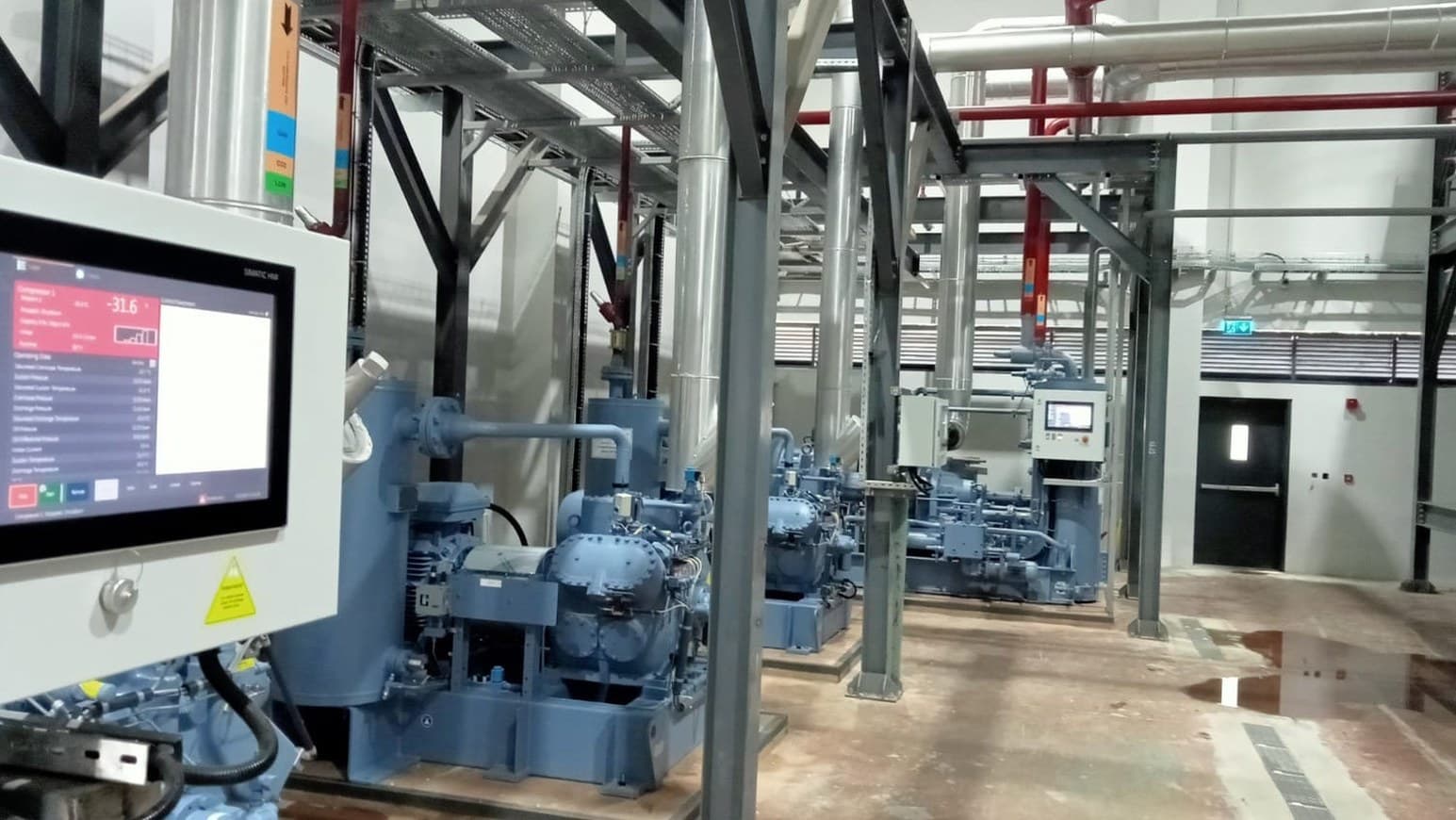 Industrial plant control equipment alongside refrigeration compressors